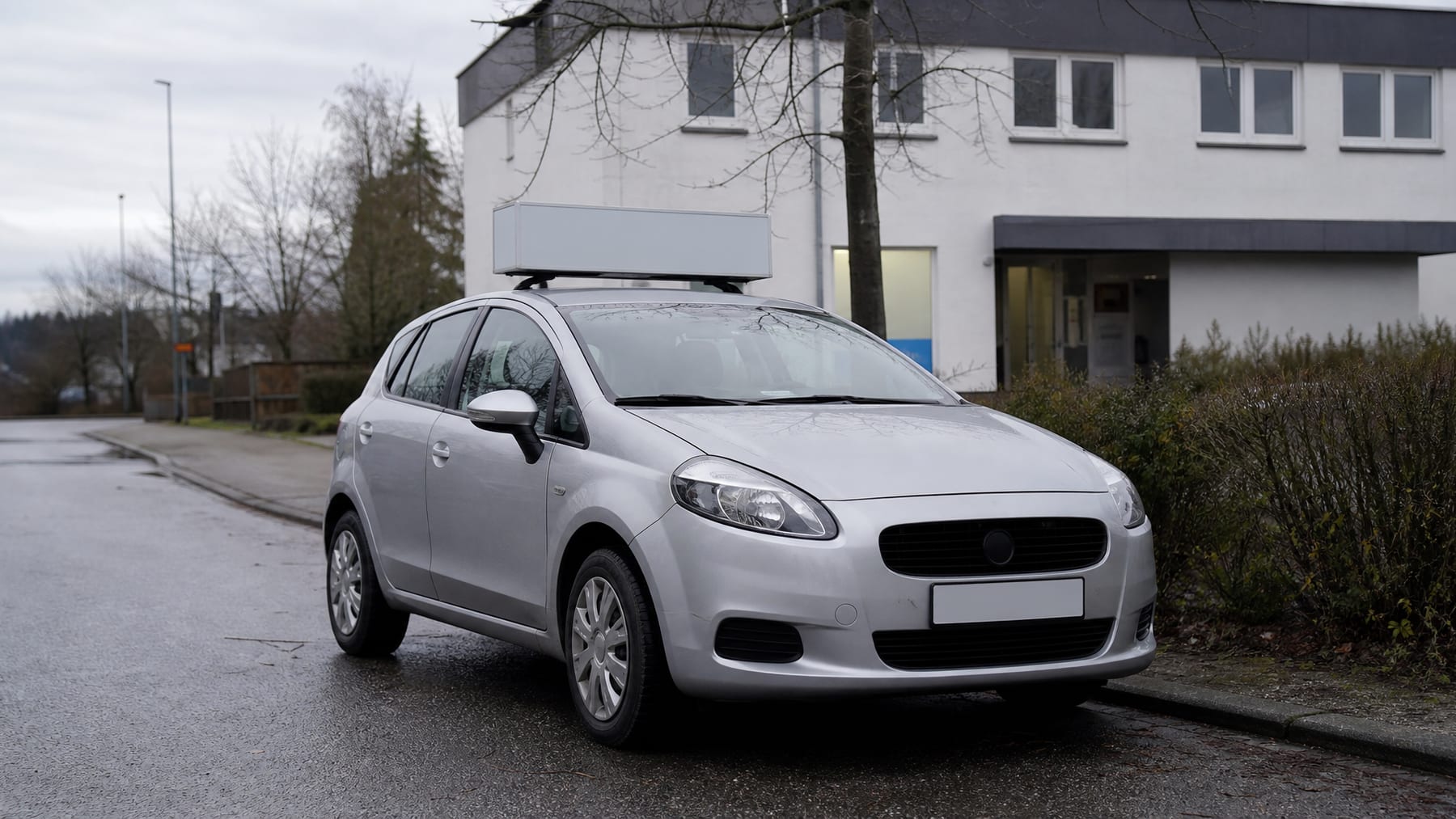 Fahrschulwagen vor dem Gebäude der Fahrschule
